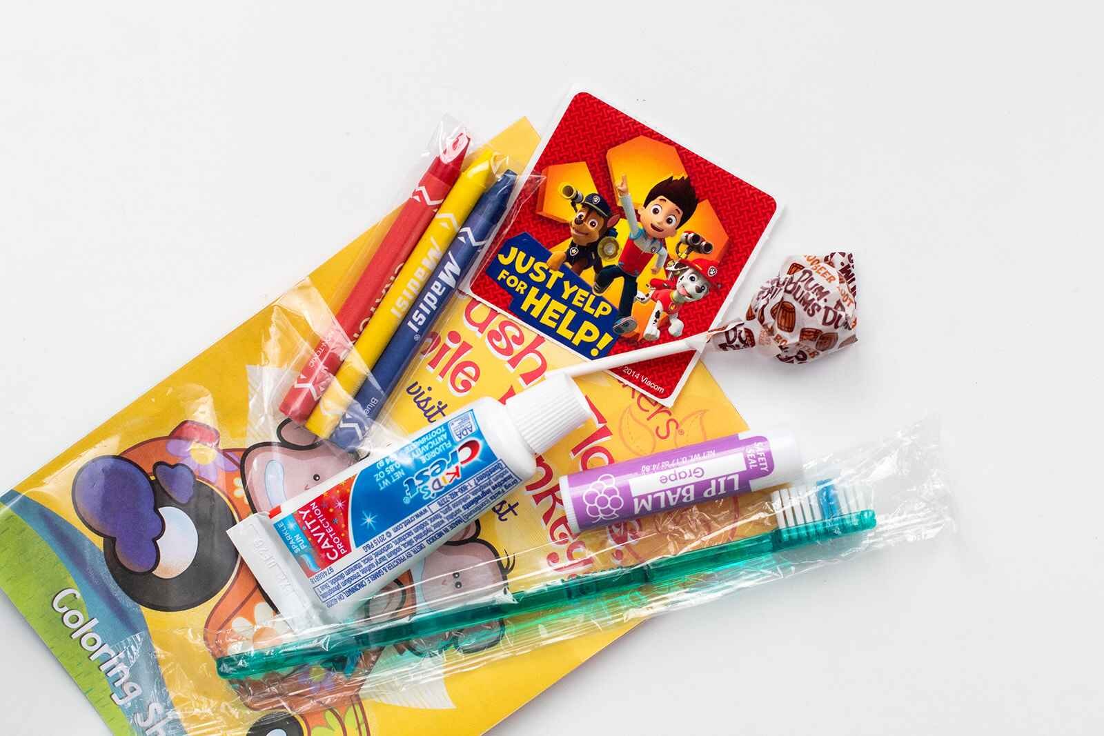 Kid's care package with tooth care, coloring, chapstick, and lollipop